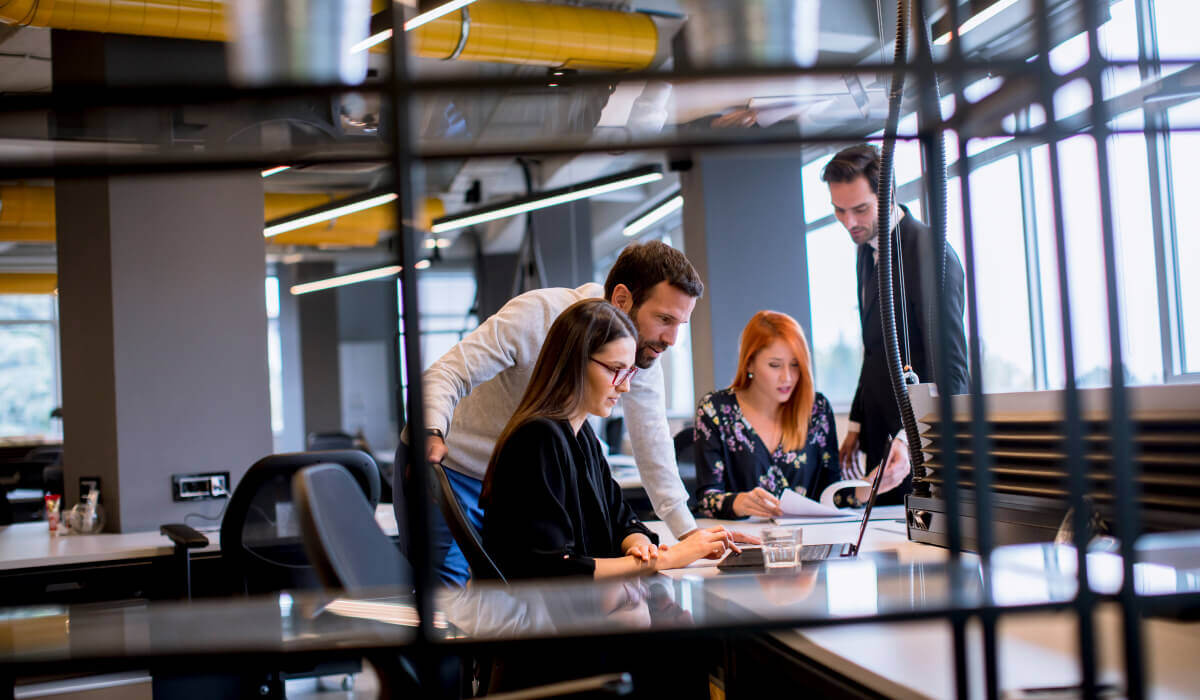 A team collaborating in an office, illustrating how brand guidelines benefit cross-departmental consistency and communication.