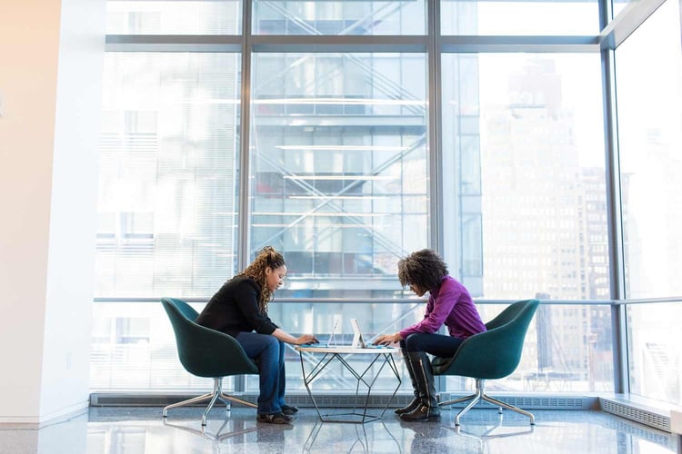 Two individuals engaged in a conversation in a bustling airport lounge, illustrating travel, communication, and connection.