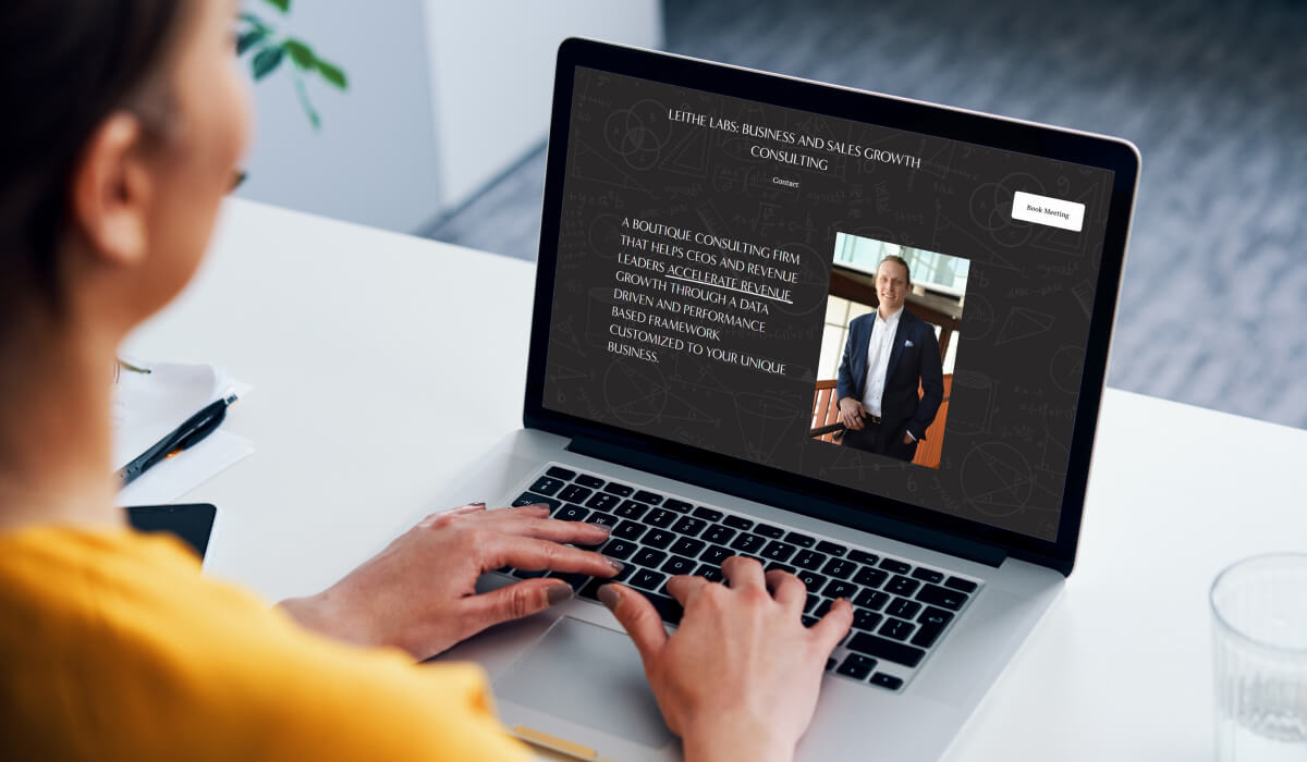 A person is visiting the Leithe Labs website on a laptop, which shows Chris Leithe--a consultant spearheading data-driven strategies for accelerating business leaders' revenue growth.