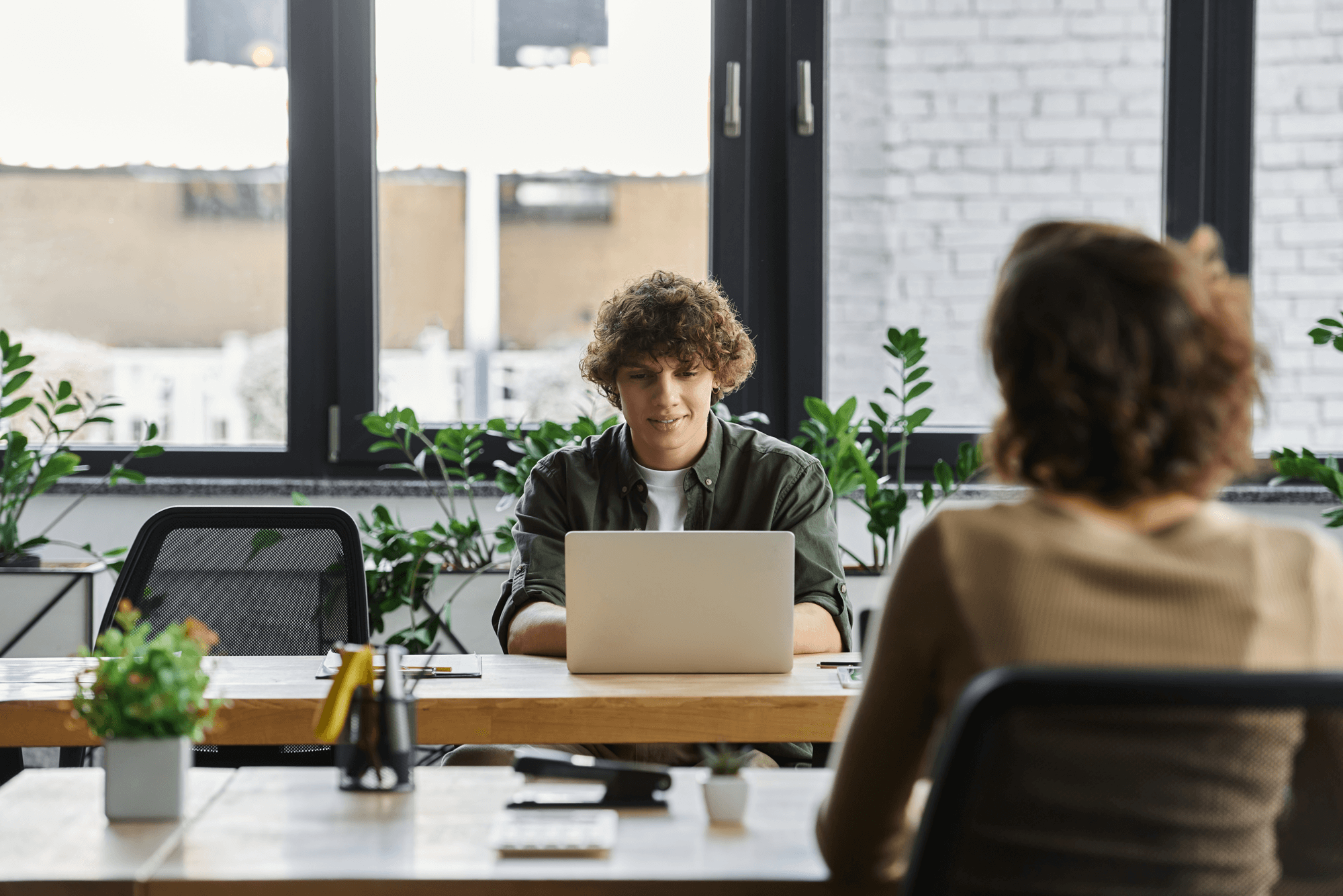 Two people meeting at a modern office table with laptops, representing Vaulted’s personalized approach and partnership in Raleigh SEO services.
